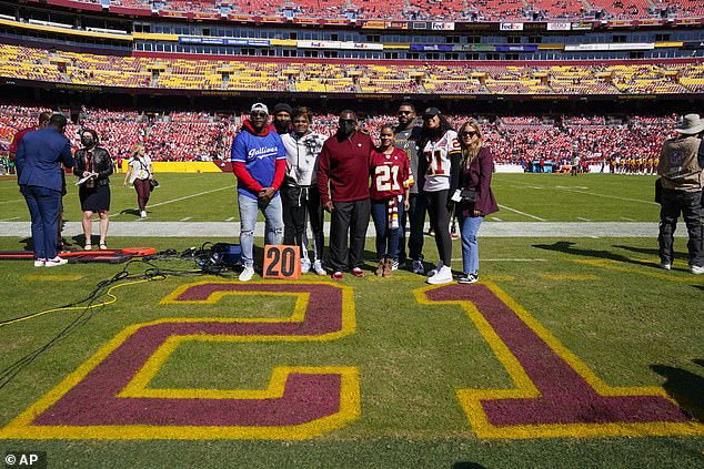 Members of the family of the late Sean Taylor gather on the field as the Washington football team retires with its number during a party before the start of the NFL football game against the Kansas City Chiefs on Sunday.  His number 21 was drawn on the sidelines near the 21-yard line