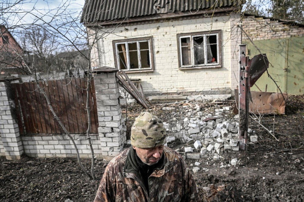 A man stands in front of a destroyed house in the bombing of the town of Stoyanka, west of Kyiv, on March 4, 2022.
