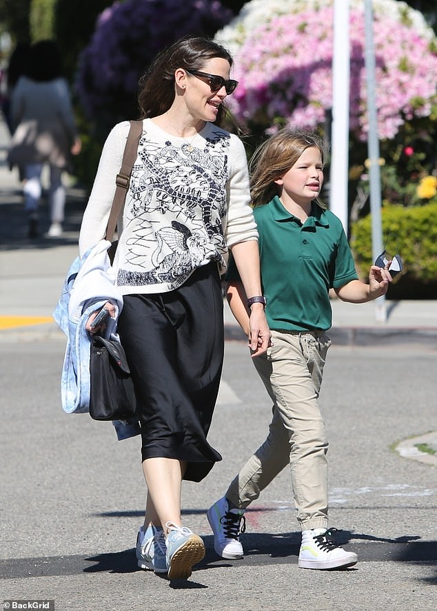 Polka dot mom: Jennifer wore a graphic T-shirt with a black skirt, adding sneakers