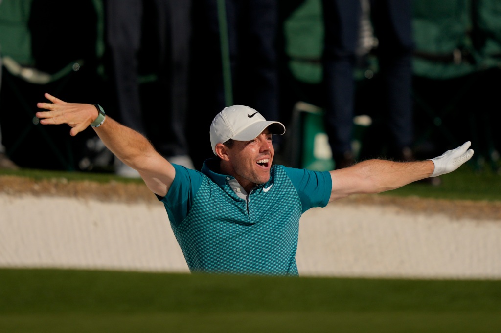 Rory McIlroy throws his club in celebration.