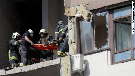 Rescue workers evacuate a person from an apartment building damaged by a Russian missile strike in Kyiv, Ukraine, June 26, 2022. 