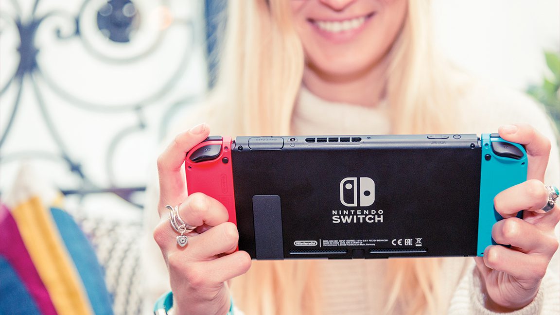 Picture of a young woman playing a Nintendo Switch game console