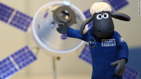 Shaun the Sheep is photographed in front of a model of the Orion spacecraft.