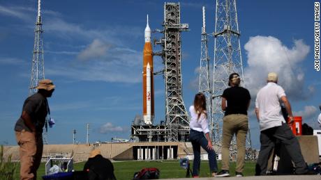 Photographers and reporters work Monday near NASA's Artemis 1 rocket at Kennedy Space Center.  A number of problems prevented it from starting later.