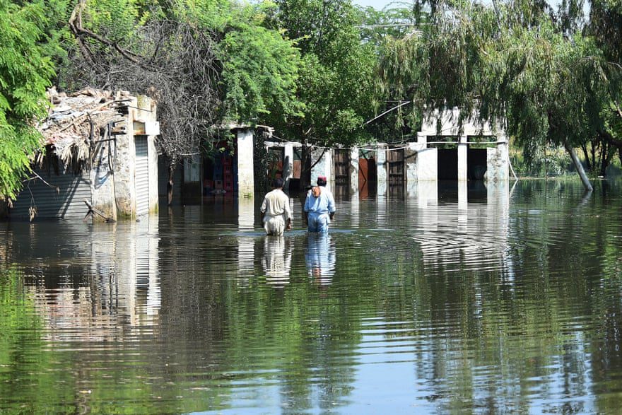 Residents wade in flood waters near their homes after heavy monsoon rains.