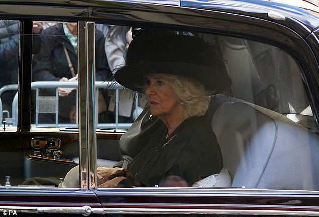 Camilla, 75, looked emotional as she followed the procession of Queen Elizabeth's coffin by car from Holyrood Palace to St Giles' Cathedral earlier today.