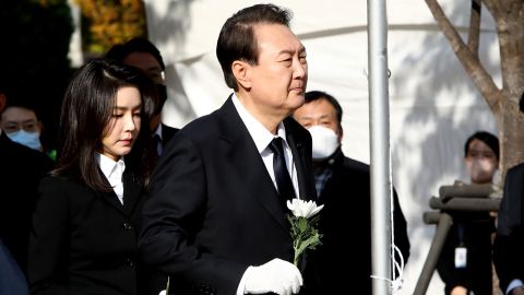 South Korean President Yun Seok-yeol and his wife Kim Geun-hee hold flowers at a memorial altar in Seoul on October 31.