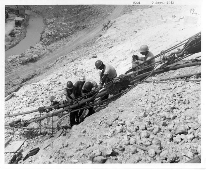 Workers tying and lifting cables supporting the platform in September 1962.