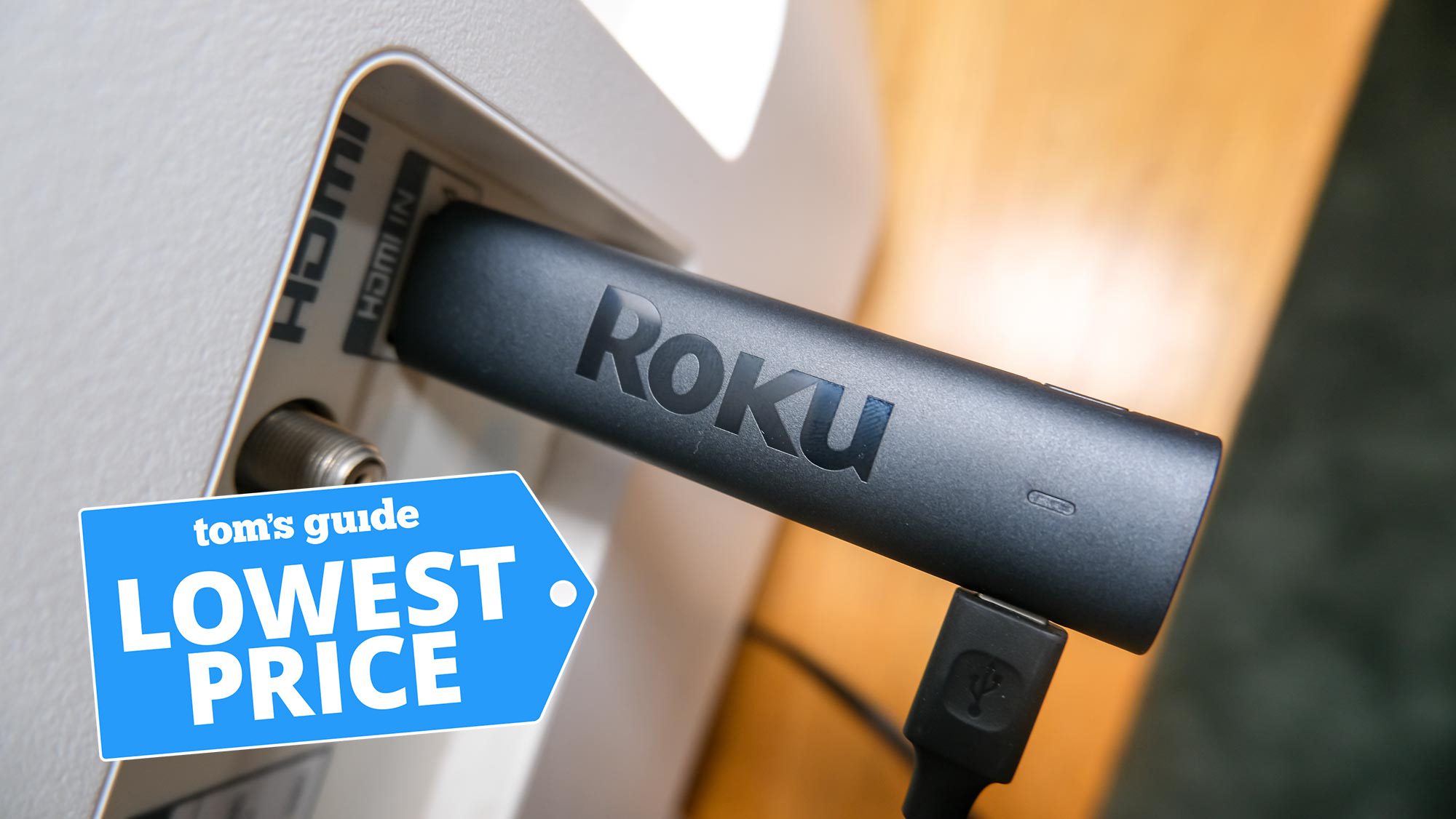 Roku Streaming Stick 4K is plugged into an HDMI port with Tom's Guide Lowest Price graphic on top